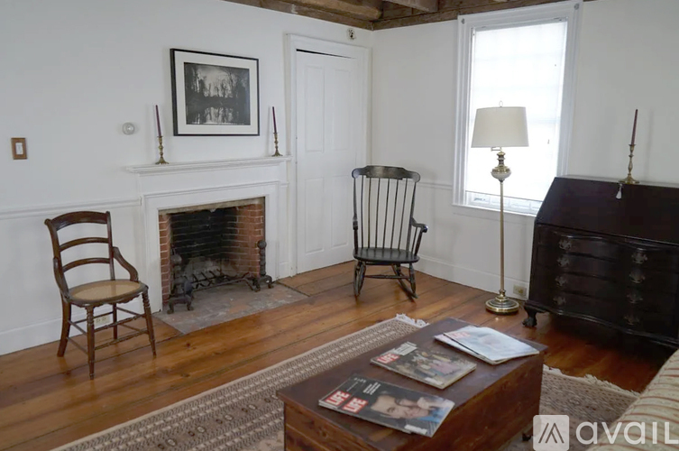 A living room with a fireplace, a chair, a coffee table, and a lamp.
