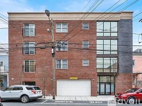 A red brick building with a white garage door in front.
