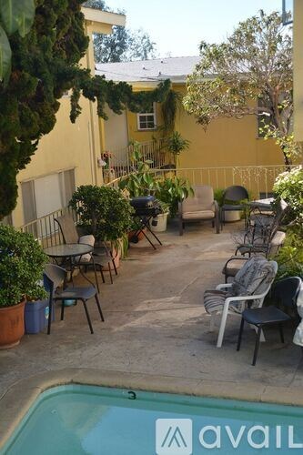A pool with chairs and plants around it.