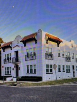 A white building with a red roof and a balcony.