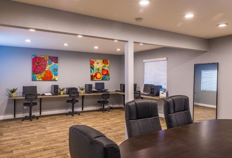 A conference room with a long table and chairs.