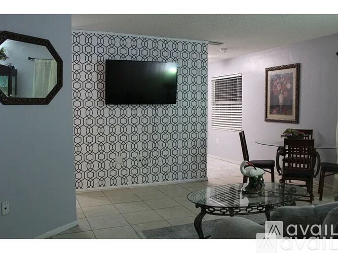 A living room with a television and a glass table.