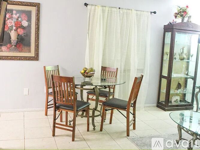 A dining room with a glass table and chairs.