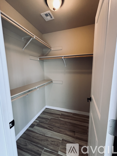 A small, empty walk-in closet with a sliding door.