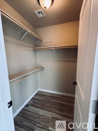 A small, empty walk-in closet with a sliding door.