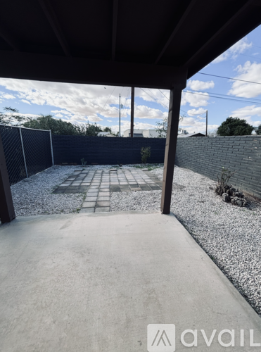 A patio area with a concrete floor and a gravel area in the middle.