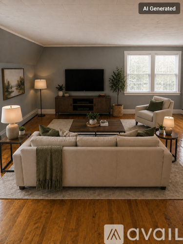 A living room with a couch, a television, and a potted plant.