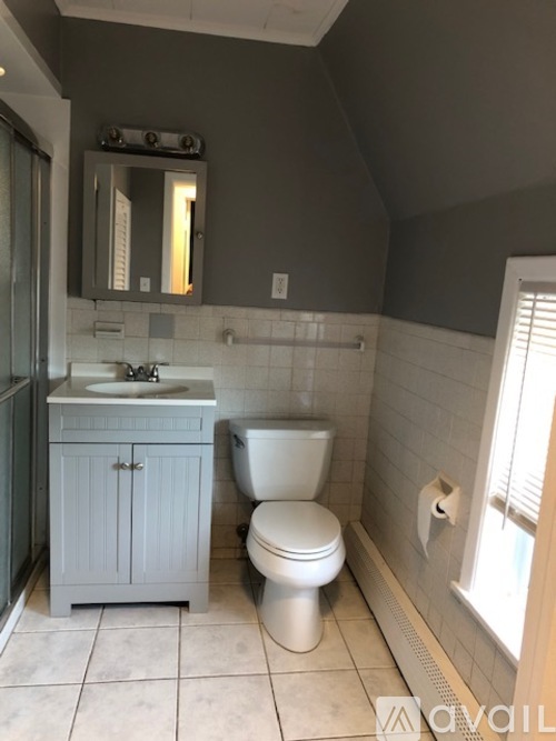 A bathroom with a toilet, sink, and medicine cabinet.