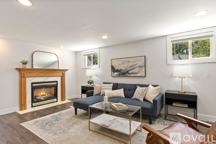 A living room with a fireplace, a couch, a coffee table, and a painting on the wall.