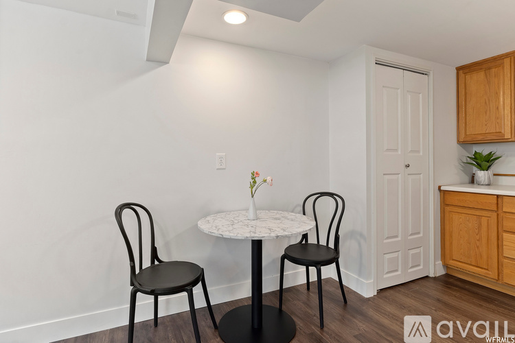 A dining room with a white table and two chairs.