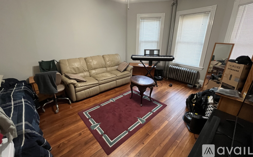 A living room with a couch, chair, and rug.