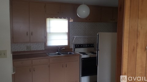 A kitchen with wooden cabinets and a white fridge.