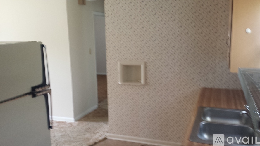 A kitchen area with a refrigerator and a sink.