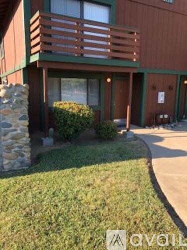 A building with a green awning and a stone pillar in front of it.