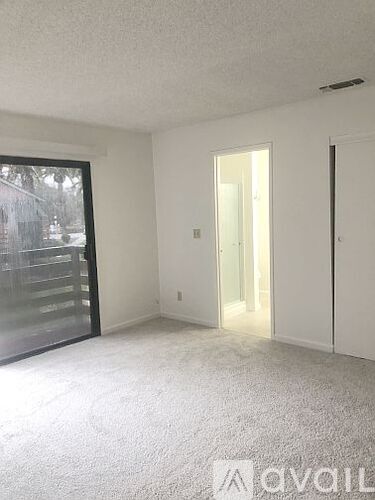 A room with a carpeted floor and a sliding glass door.