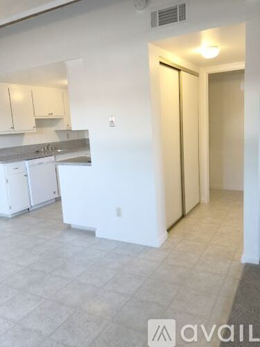 A kitchen with white cabinets and a counter top.