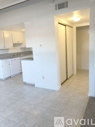 A kitchen with white cabinets and a counter top.