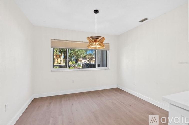 A room with a window and a hanging light fixture.