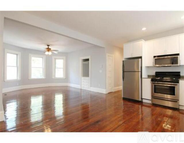 A kitchen with stainless steel appliances and wooden floors.