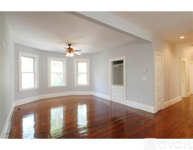 A room with wood floors and a ceiling fan.