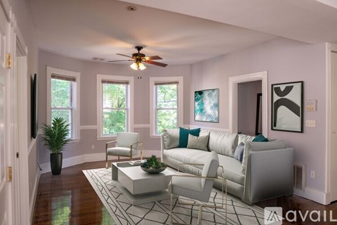 A living room with a white couch and a rug.