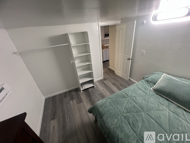 A bedroom with a bed, a dresser, and a closet.