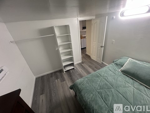 A bedroom with a bed, a dresser, and a closet.