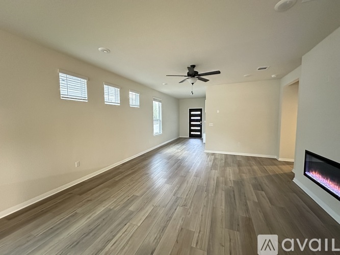 A spacious room with a fireplace and a ceiling fan.