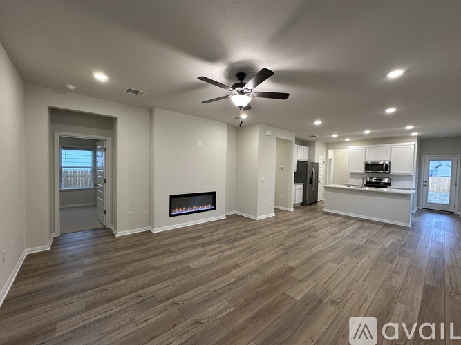 A spacious living room with a fireplace and hardwood floors.