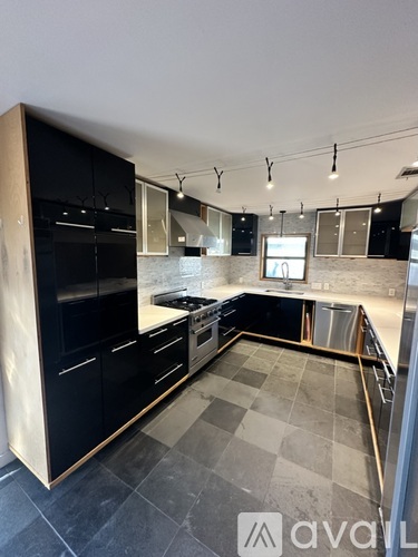 A modern kitchen with black cabinets and a checkered floor.