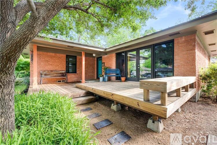 A house with a red brick exterior and a wooden deck.