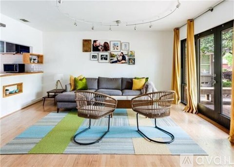 A living room with a grey couch and two chairs.