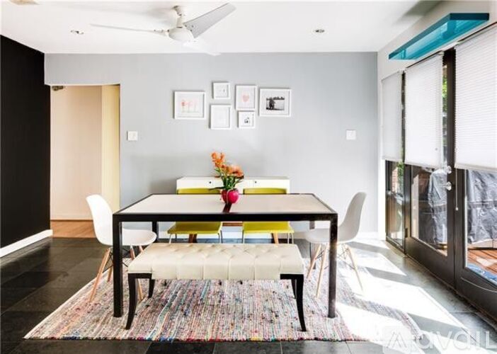 A modern dining room with a black table and chairs.