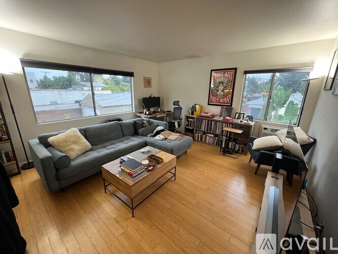 A living room with a grey couch, a coffee table, and a bookshelf.