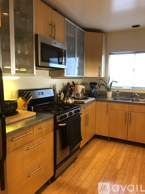A kitchen with wooden cabinets and black appliances.