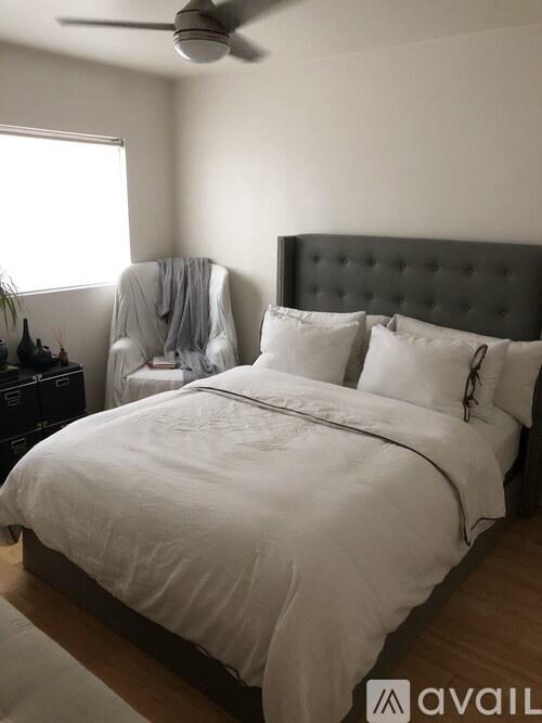 A bedroom with a large bed and a ceiling fan.