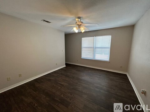 A room with a ceiling fan and a window with blinds.