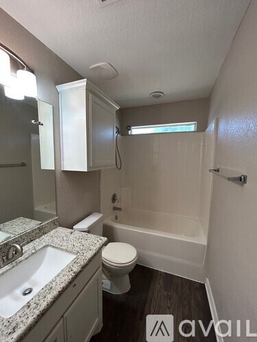 A bathroom with a sink, toilet and bathtub.