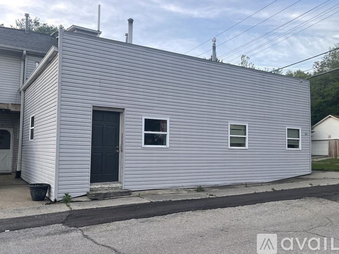A grey house with a black door and windows.