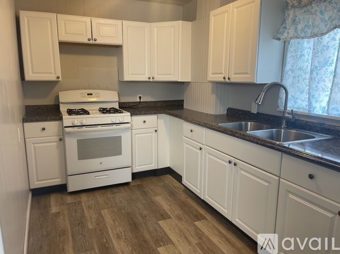 A kitchen with white cabinets and a stove top oven.