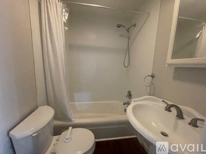 A white bathroom with a toilet, sink, and bathtub.
