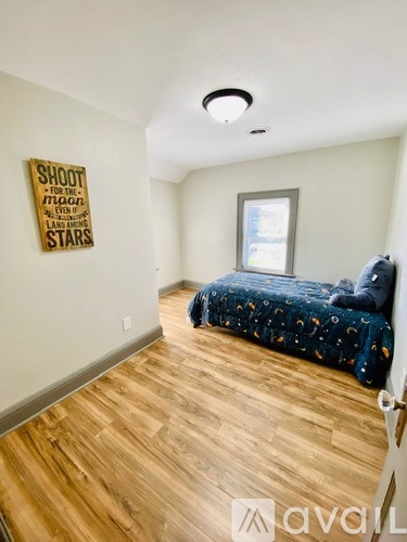 A bedroom with a bed and a poster on the wall.