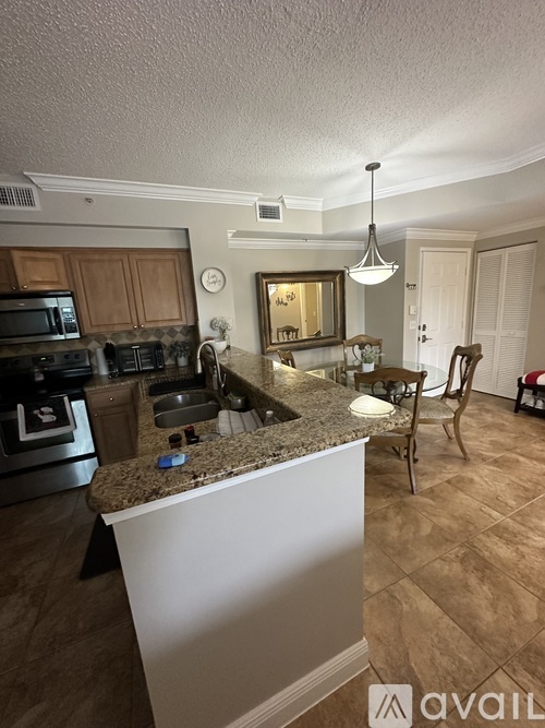 A kitchen with a granite countertop and a white island.