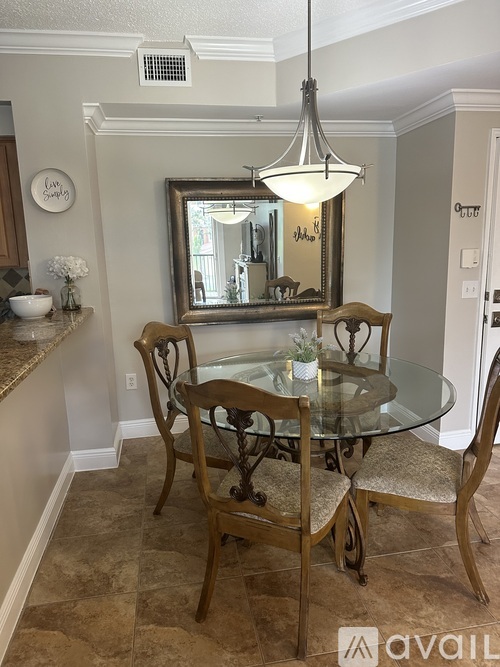 A dining room with a glass table and chairs.