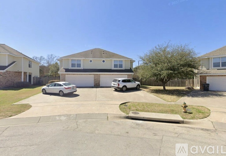 A white car is parked in front of a house.