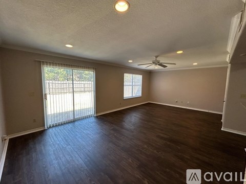A room with wooden flooring and a ceiling fan.