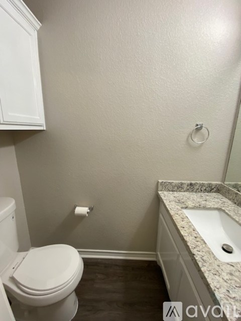 A white toilet sits next to a sink in a bathroom.