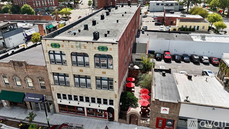 A street view of a city with buildings, cars, and a red awning.