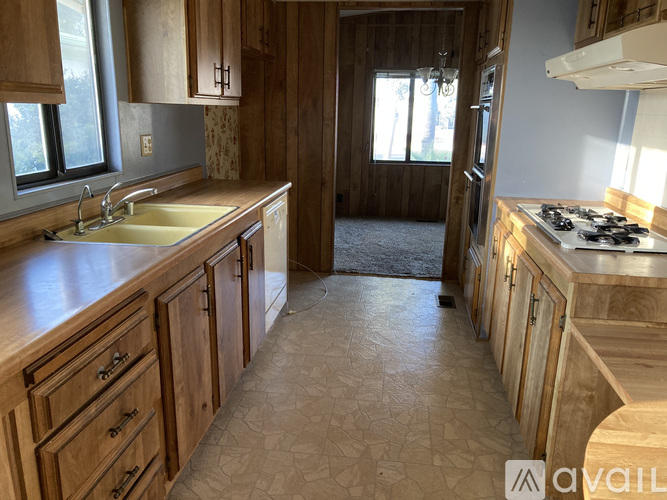 A kitchen with wooden cabinets and a tiled floor.
