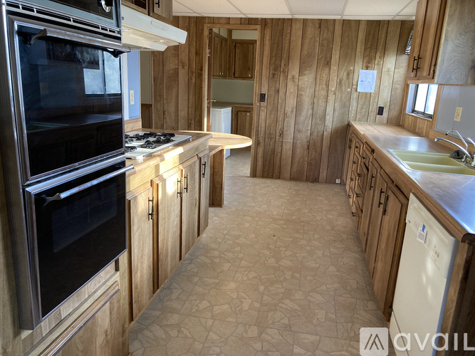 A kitchen with wooden cabinets and a black oven.